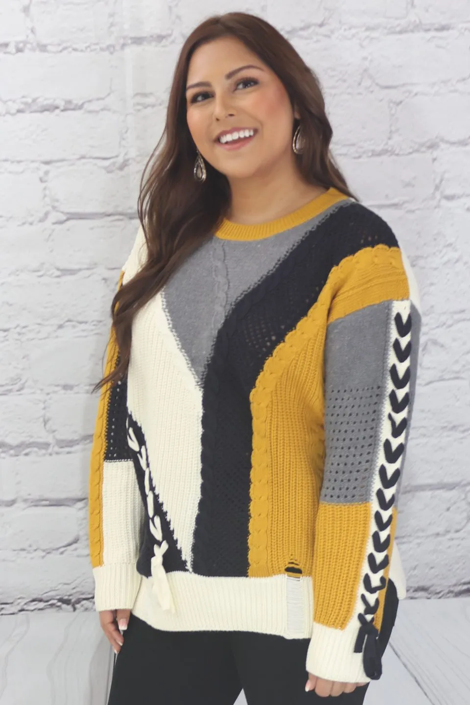 Long sleeve color block cable knit sweater with lace-up trim